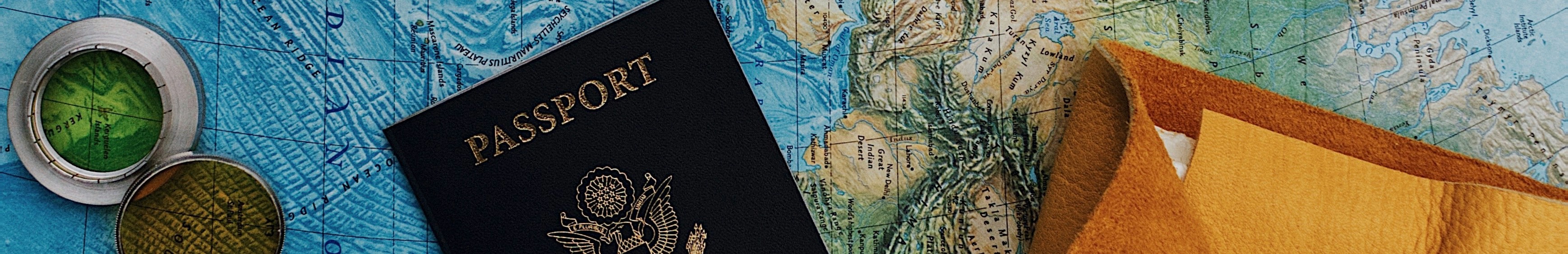 Passeport et appareil photo posés sur une carte du monde.
