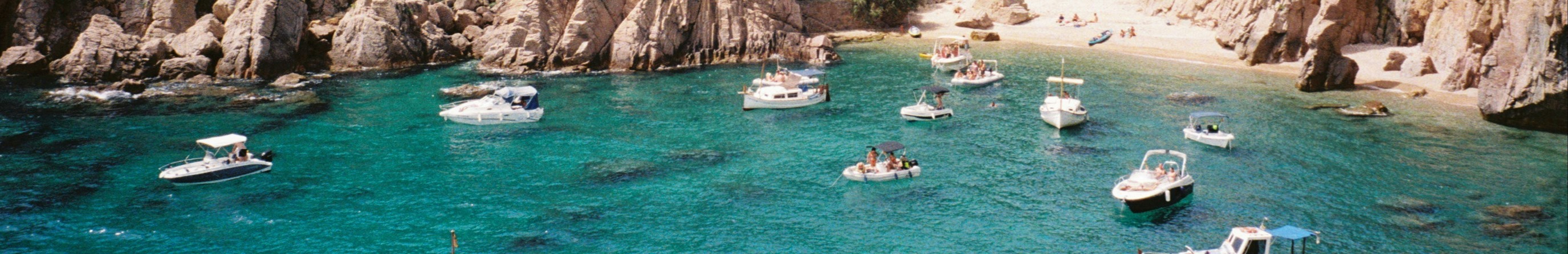 Groupe de bateaux flottant sur une eau turquoise claire.