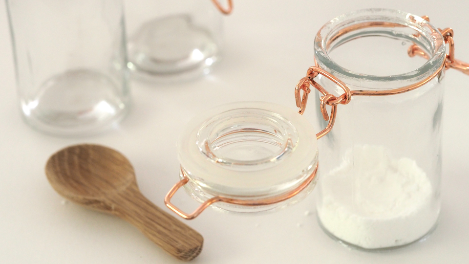 Glass jar of flour with a wooden spoon 