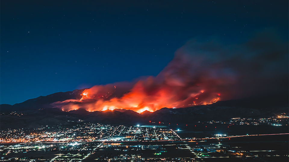 Fires burning nearby a city in California at night.