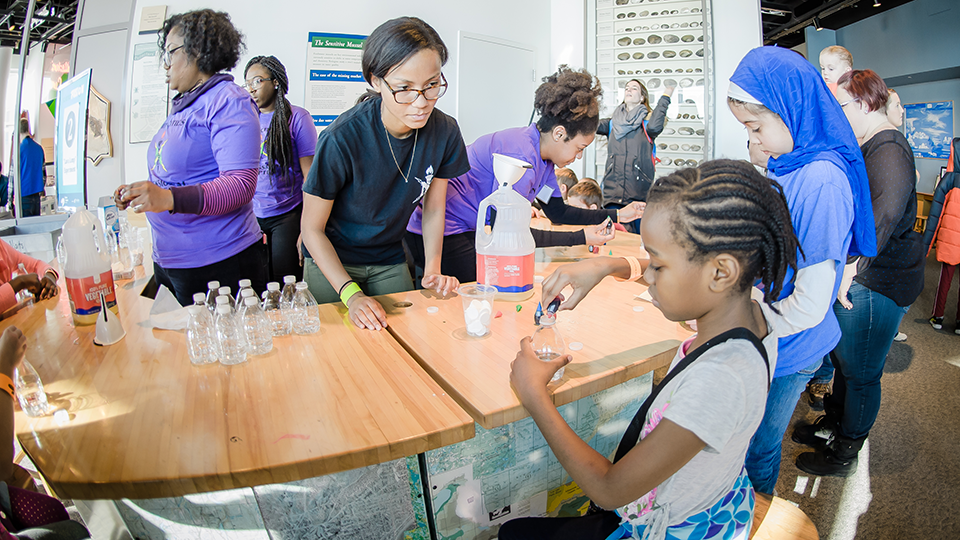 Image of women at the Science Fusion African Americans in STEM celebration looking at a science experiment