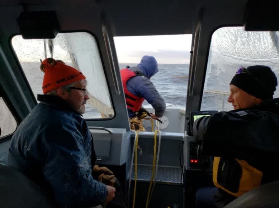 Research scientist Shane Bowe, Red Lake DNR, Mark Edlund and Adam Heathcote traveling on a boat.