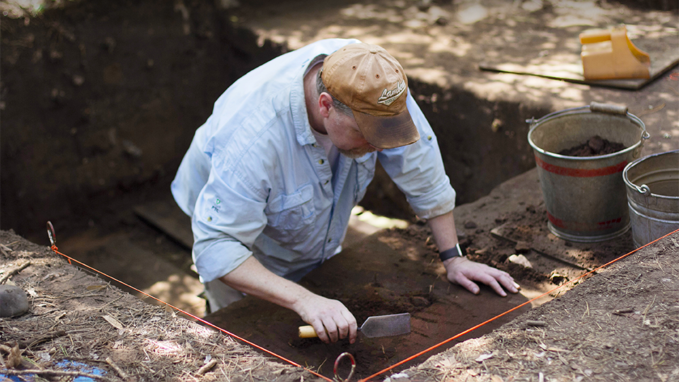 Dr. Ed Flemming examining some earth. 