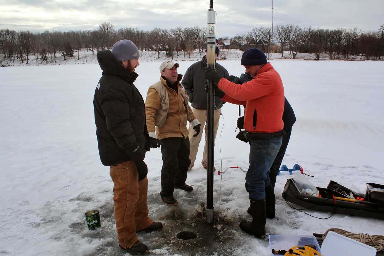 January 2015: The crew uses an auger to drill holes through a foot of ice on Miller Lake, in Carver County. Gathered around the hole, they perform some calculations, plunge a tube into the water and into the mud on the bottom, and then pull it back up. Winter is a great time to take sediment samples. Once the ice is thick enough, it provides a much steadier and more spacious working surface than a boat bobbing on liquid water. There’s also no risk of drifting away from the study site. 