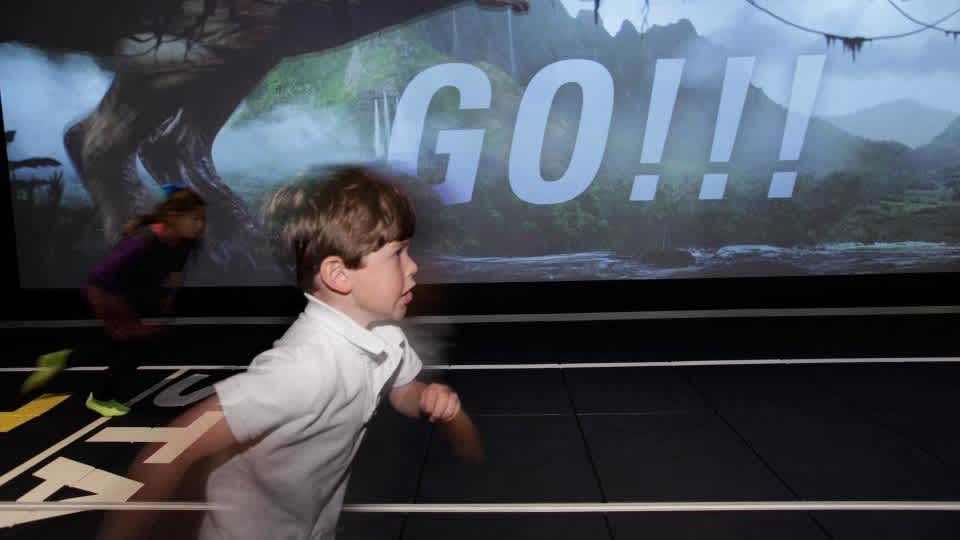 Child racing a T. rex in the Run feature