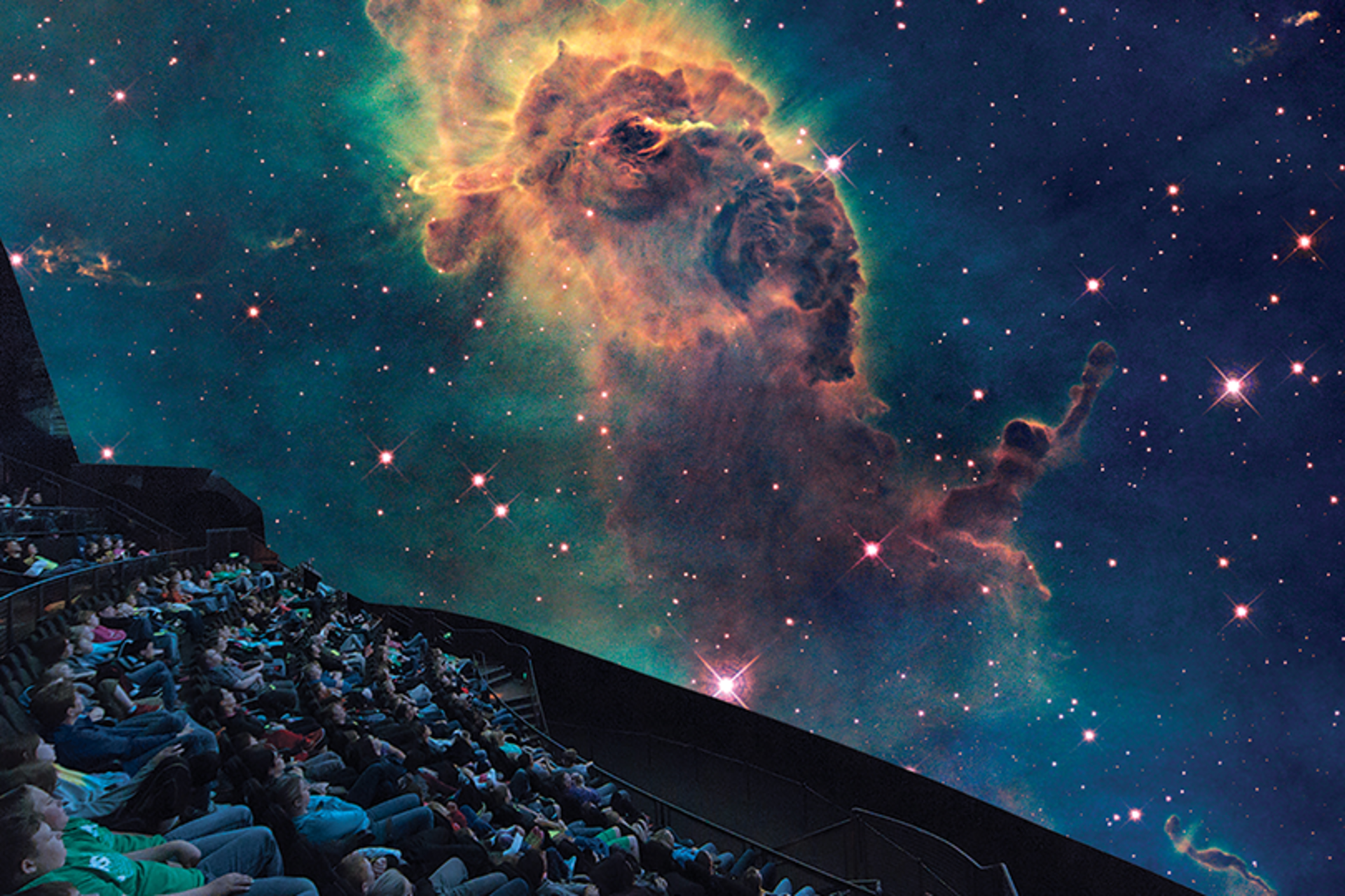 A photo of the Omnitheater with the audience viewing a projection of space.
