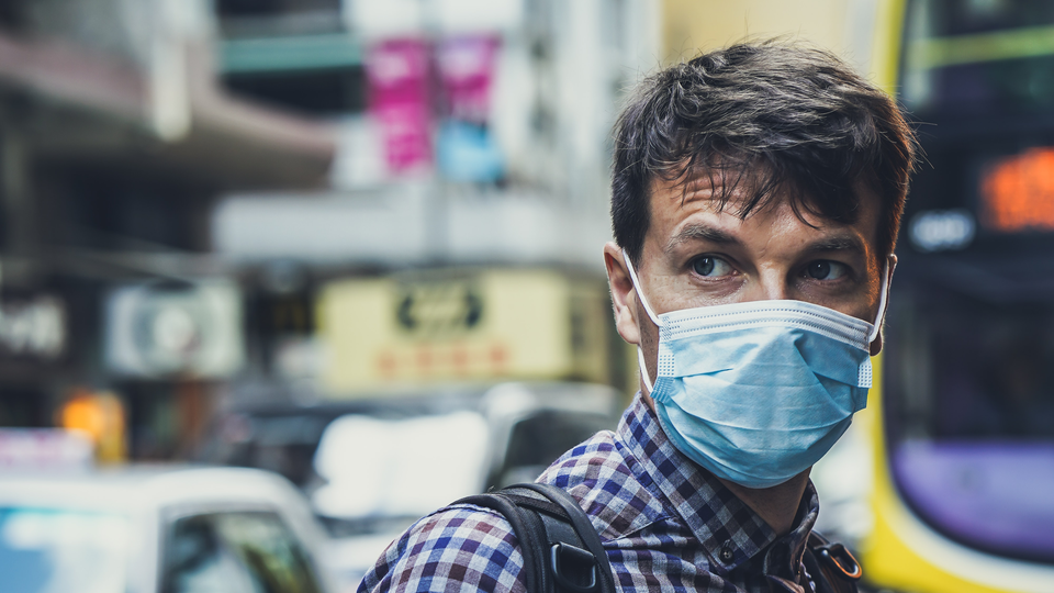 Man wearing a face mask in an urban area