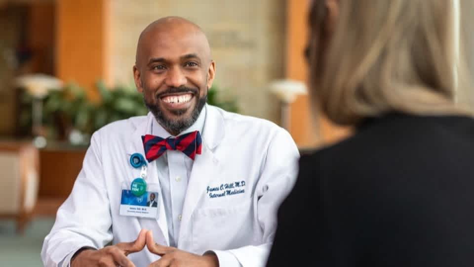 Dr. James Hill in a lab coat and bowtie.