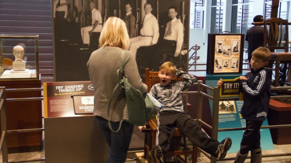 Two children and a parent explore the Weighing the Evidence exhibit. 