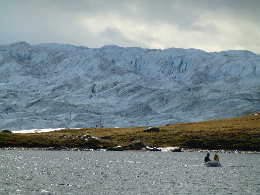 Researchers travel across a lake on a trip to Greenland.