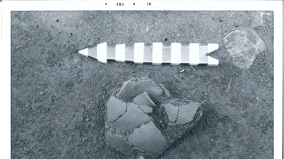 An archeological dig rock with an arrow above it