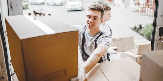 Deux jeunes hommes déchargeant des cartons d'un camion