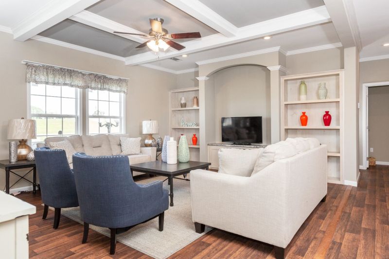 There's a living room with beige walls, a built-in entertainment area, beamed ceiling plus white and navy furniture.