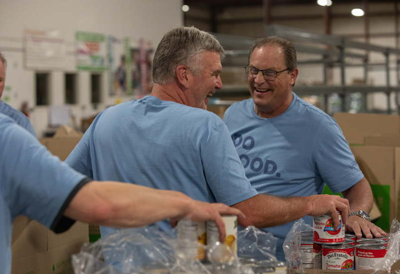 People stack canned goods smiling
