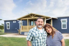 Couple standing in front of their Custom Clayton built home