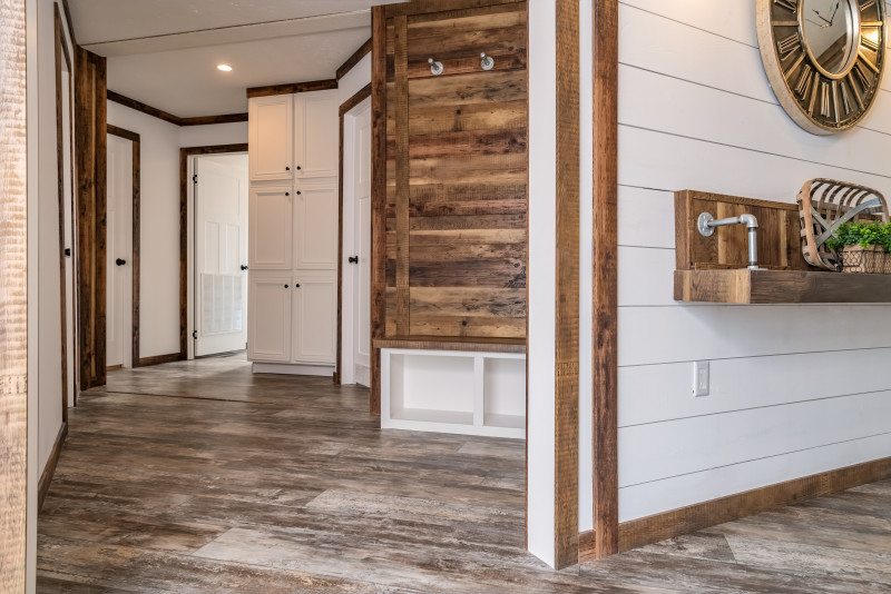 An open entryway with floor to ceiling white cabinets and natural wood features.