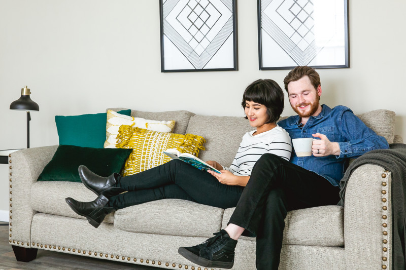 Couple sitting in the living room of their manufactured home with a book and coffee.