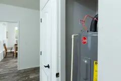 Rheem water heater in a closet in the hallway of a manufactured home