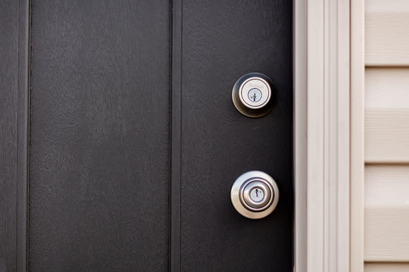 Silver Kwikset handle and lock in a dark brown manufactured home door.