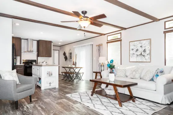If you you like traditional home styles with a bit of rustic, you'll exclaim over The Anniversary Islander.  Check out the spacious open floor plan, and enjoy features like weathered-style floors, ceiling beams, dark cabinets and subway-tile backsplash.