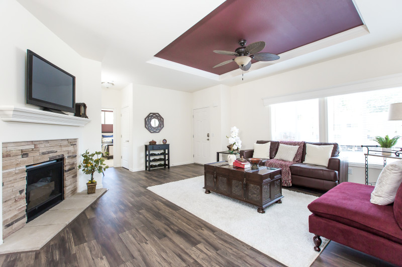 A manufactured home living room with a dark plum tray ceiling.