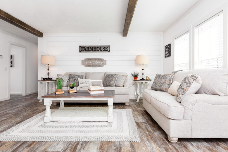 Farmhouse styled manufactured home with white shiplap walling and wide plank wood floors.