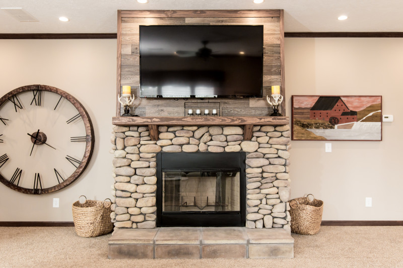 Manufactured home entertainment center with a river stone fireplace and TV.
