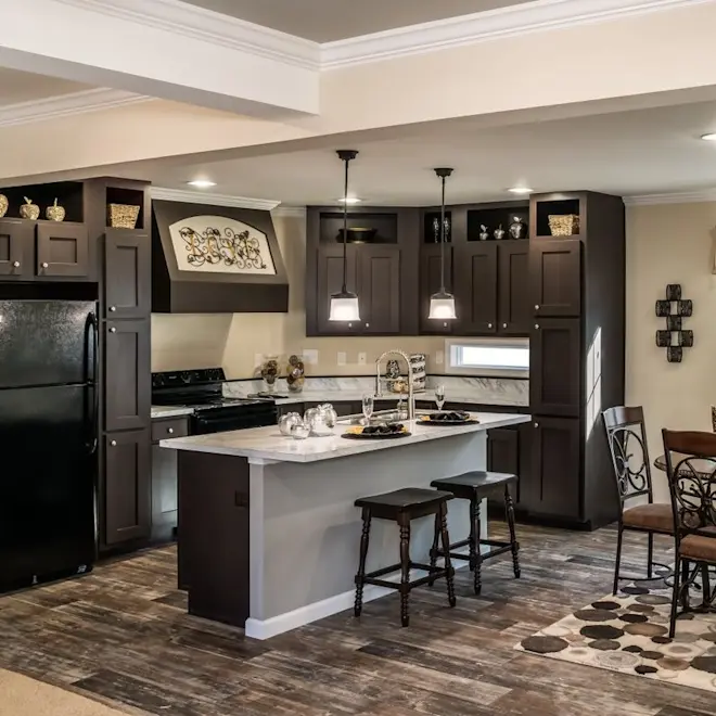 These bright hanging pendant lights add a modern touch to this traditional style kitchen. With large wood cabinets, stylish countertops and a spacious kitchen island, The Freedom 3252 kitchen is a space the entire family can enjoy.