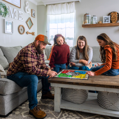 Robert and Chasity Woody sit inside their stylish, affordable Clayton manufactured home with their two daughters.