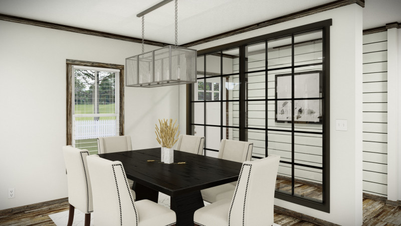 Dining area of a manufactured home with white chairs, dark wood table and window, with a window wall behind showing a foyer with a shiplap accent wall.