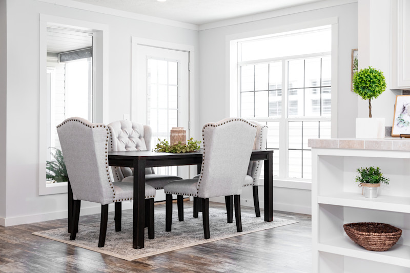 View shows dining room with large windows and a dining table with chairs.