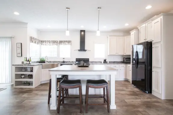 The [model name] features a kitchen with a large kitchen island and tons of cabinets.
