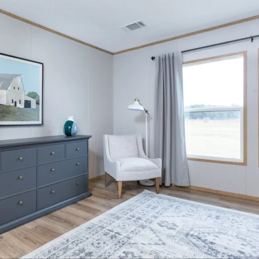 [Model Name] bedroom features ceiling trim, a gorgeous big bay window and gray walls.