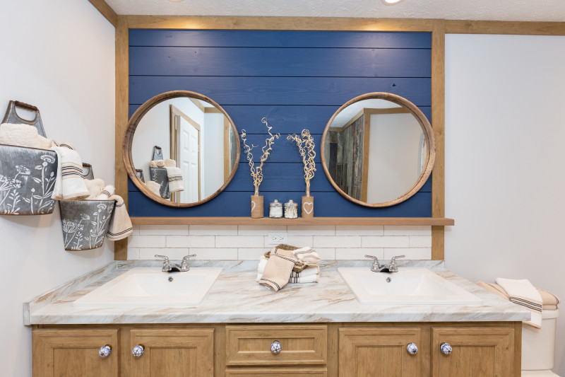 Double vanity sinks with a blue accent wall and two mirrors.