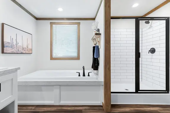 The [model name] features a subway-tiled shower and drop-in bathtub.