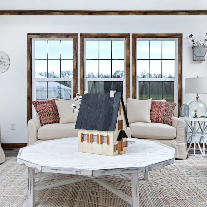 This modern farmhouse style living room from The Liza Jane has large windows for ample natural light, wood trim and a shiplap accent wall. 