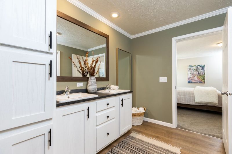 white cabinetry with dark counters in green bathroom