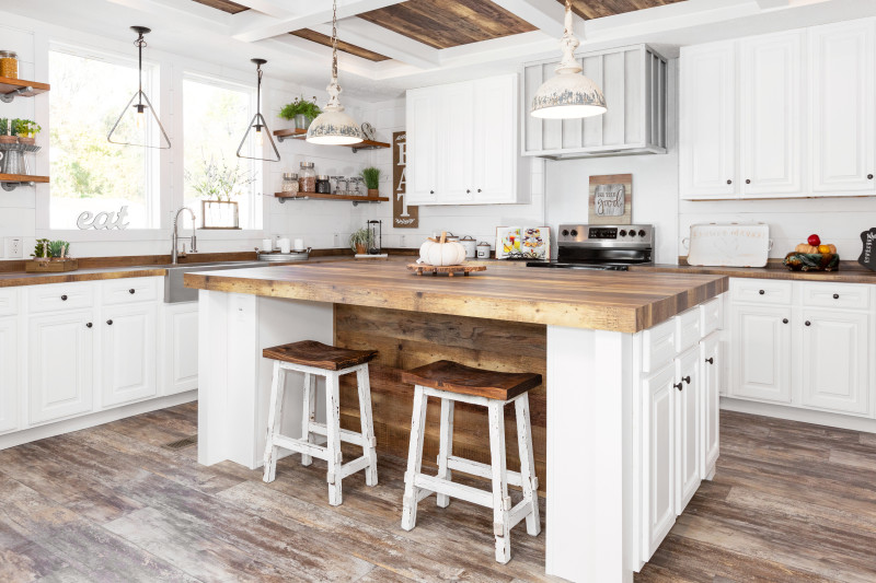 Farmhouse style island kitchen with beautiful white cabinetry and wooden vaulted ceilings.