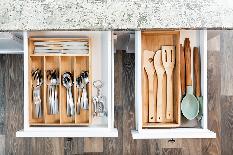 An organized kitchen drawer filled with flatware and kitchen utensils.