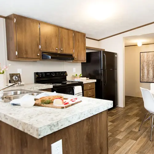 The kitchen in Bliss features L-shaped counters and warm wood-style cabinets.