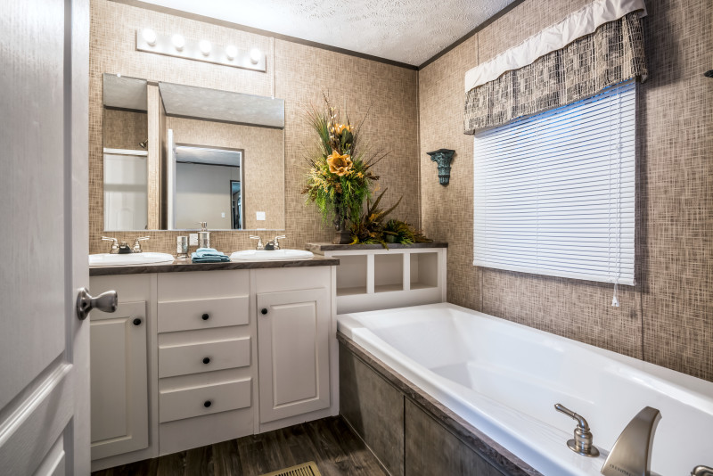 Bathroom with soaker tub, some shelving, and a white double vanity.