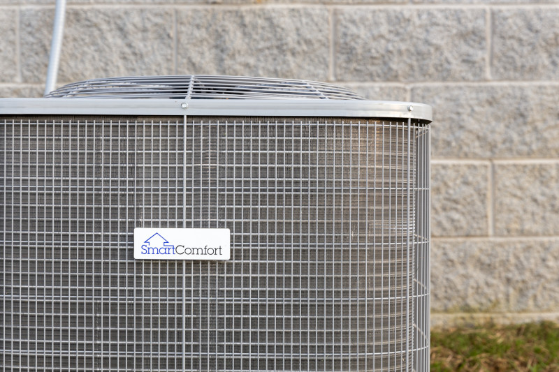 Close-up of a SmartComfort by Carrier heat pump outside of a manufactured Clayton home