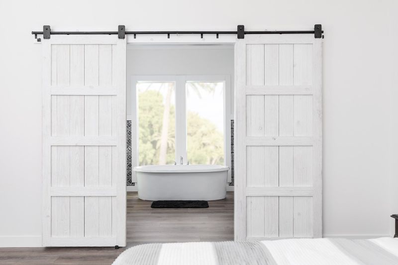 White barn doors leading into bathroom from primary bedroom
