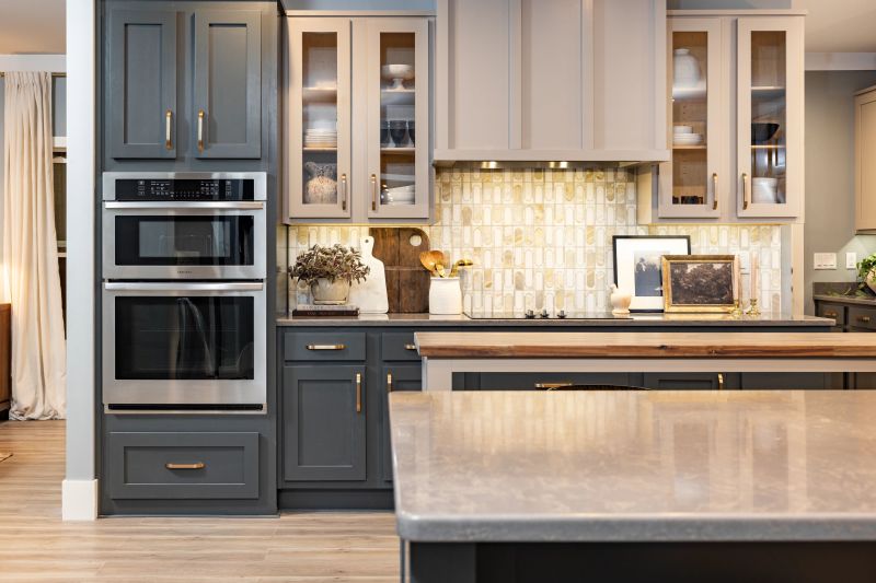 Kitchen of a Clayton manufactured home with blue-gray and gray cabinets, tile backsplash, an island and decor