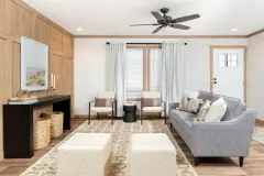 A manufactured home living area with open floor plan, modern living room design, white walls with a natural wood accent wall and natural wood trim