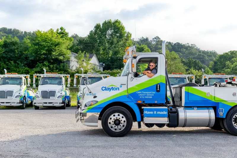 Man driving a Clayton truck used for housing transportation.