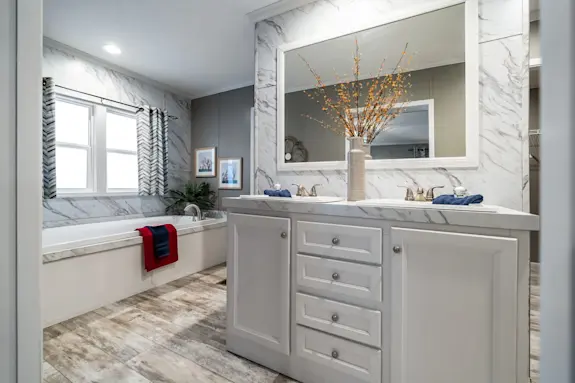 The [model name] features a drop-in bathtub and hidden shower with double shower heads.