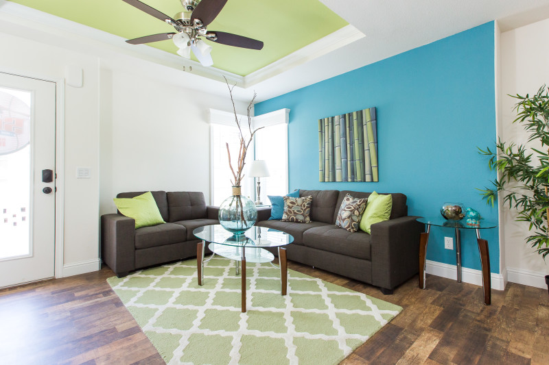 Living area of Clayton Built® home with blue accent wall and green tray ceiling.