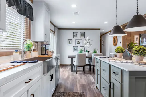 The Everett has a modern French country design with a large kitchen island and a stainless steel apron sink.