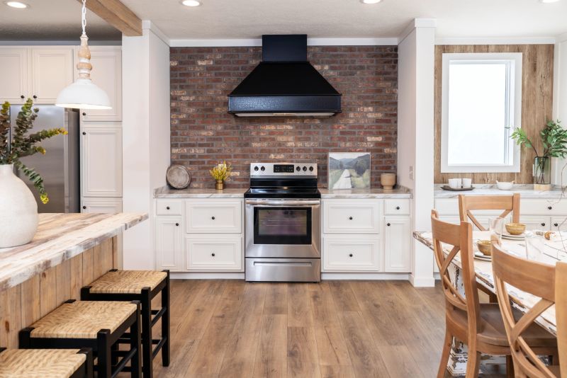 Kitchen with white and light wood accents, plus there's an brick accent wall directly in the center above the oven.